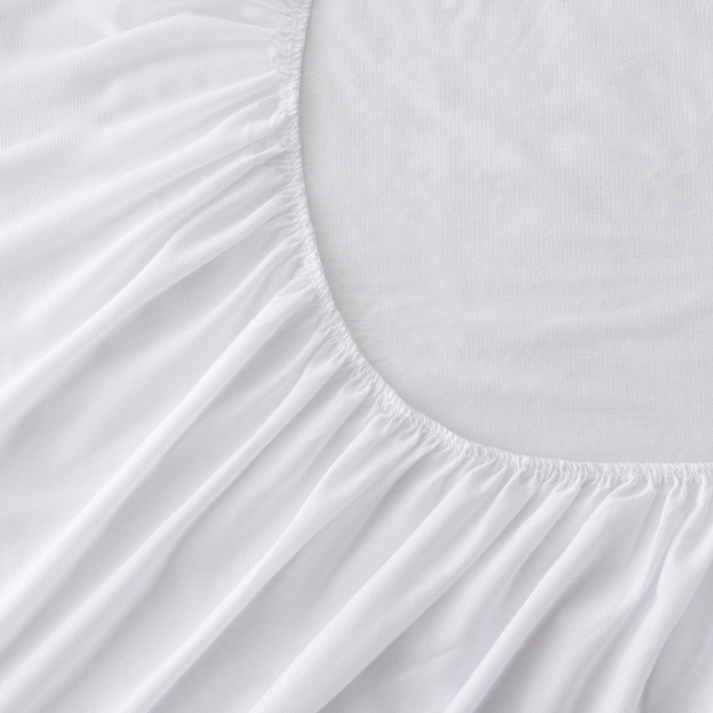 Fully fitted mattress protector showing the elastic skirt and secure fit