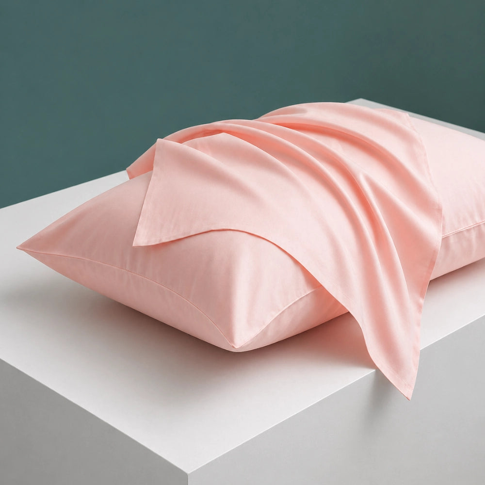 blush pink pillowcase draped over pillow showing soft cotton pillowcase feel