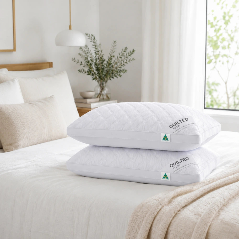 Quilted pillows stacked on bed in bright luxury bedroom