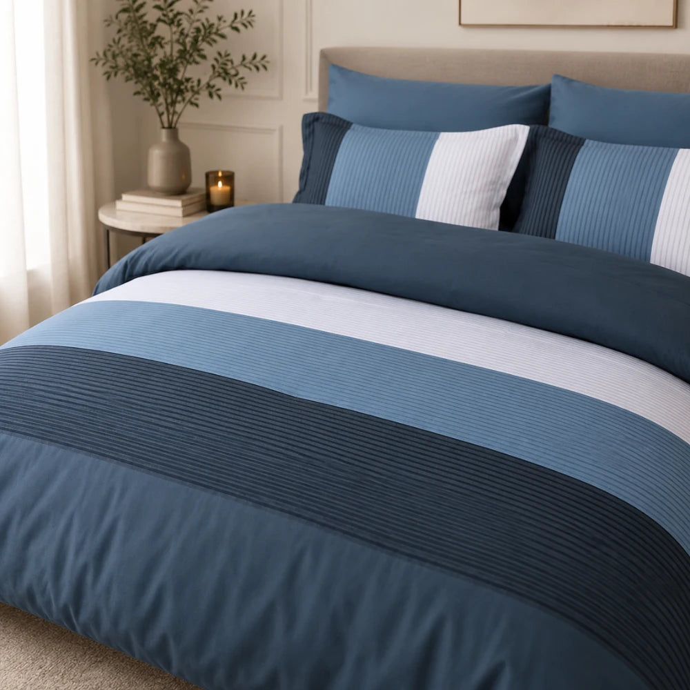 Blue summer comforter with striped panels styled on a modern bed