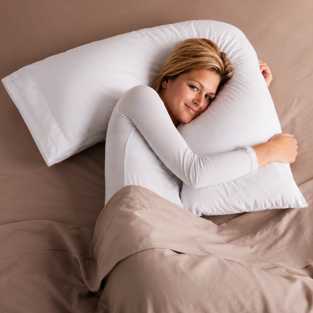 Woman sleeping comfortably while hugging a V pillow in bed