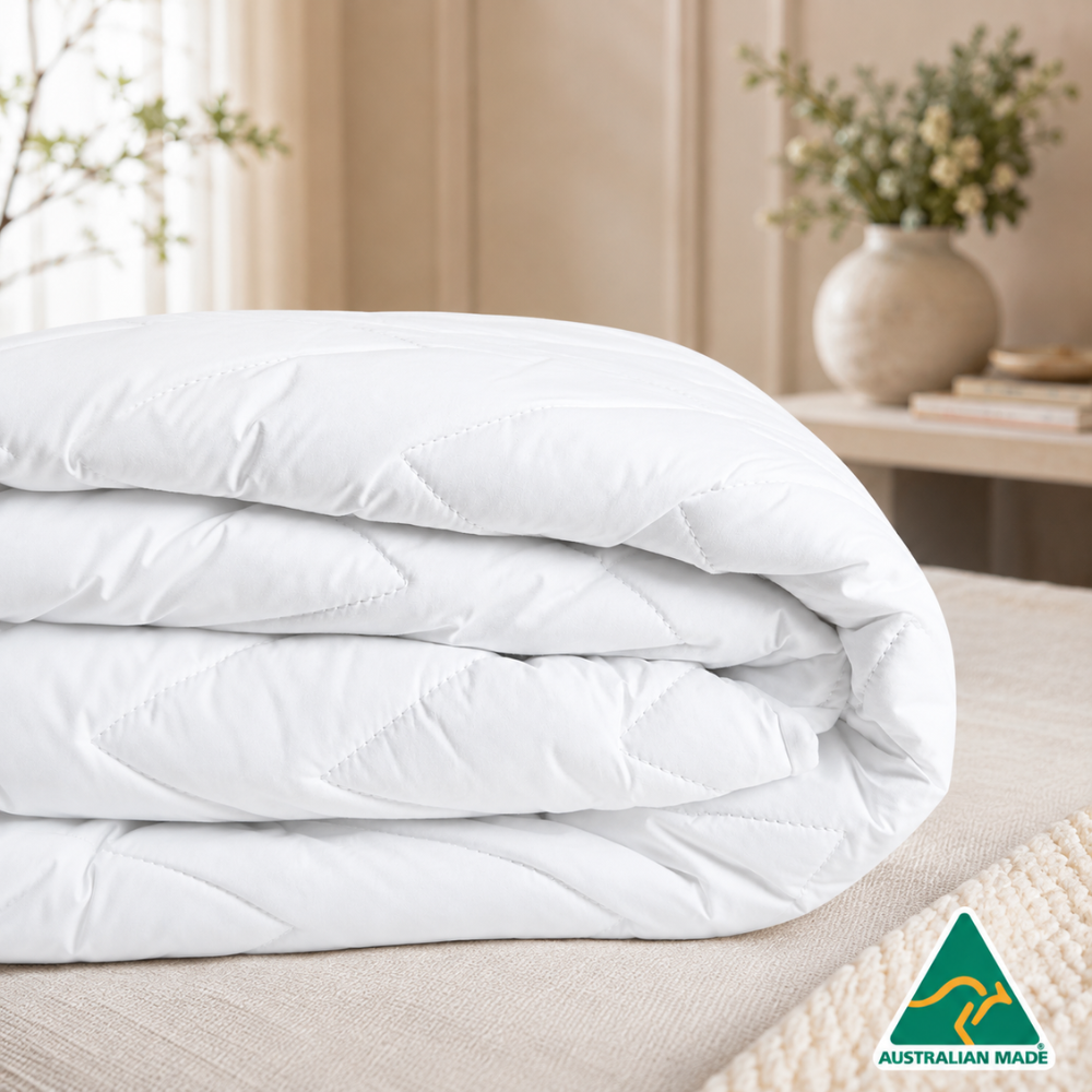Folded cotton mattress protector showcasing premium quilted comfort