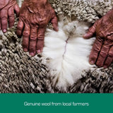 hands holding raw wool fibres showing natural australian merino wool quality
