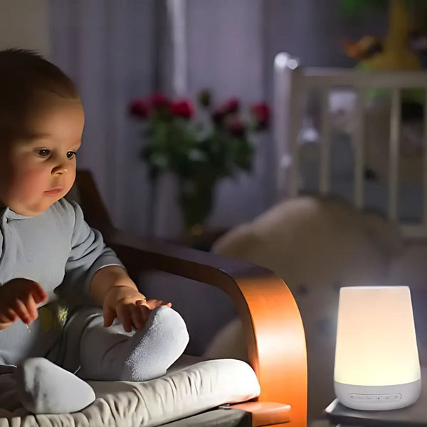 Curious baby looking at white noise machine with warm night glow, helping improve sleep environment.