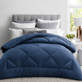 Navy quilt styled in a bright bedroom highlighting breathable bedding