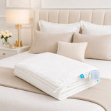 Cloud White cooling blanket folded on a luxury beige bedroom bed setting