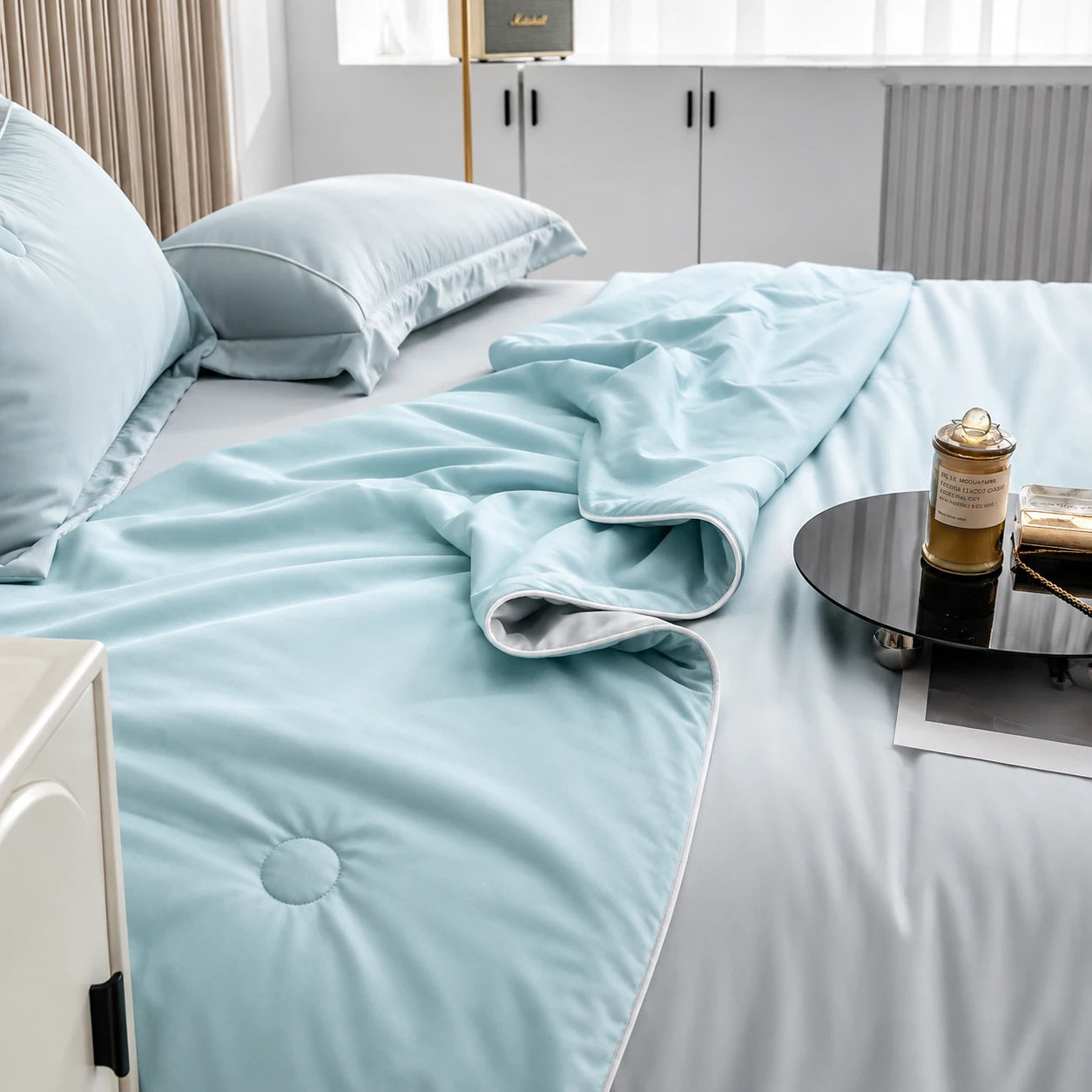 Coastal Blue cooling blanket styled with soft folds on bedding
