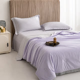 Lavender Haze cooling blanket styled on an upholstered bedroom bed