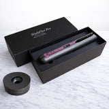 Hair straightener opened and resting flat on a marble surface