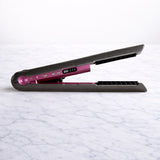Cordless straightener shown in the box with charging base on marble