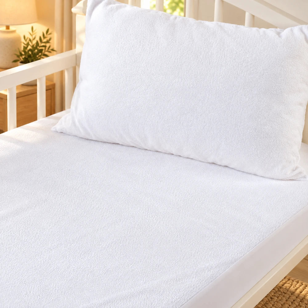 Soft cotton terry mattress protector fitted on a bed