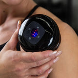 Hand holding cupping device on shoulder for tension relief