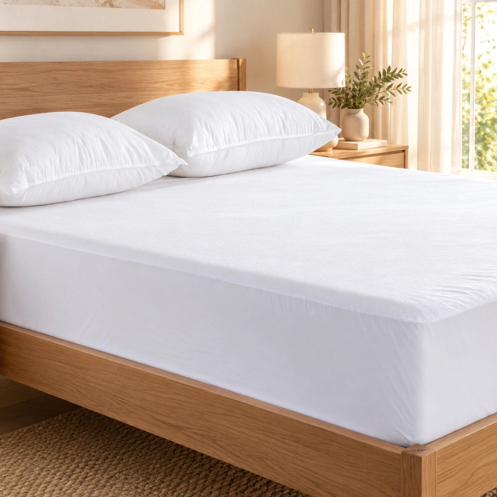 DreamGuard mattress protector fitted on a timber bed in a warm bedroom