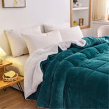 teal fleece quilt draped across bed adding plush warm bedding