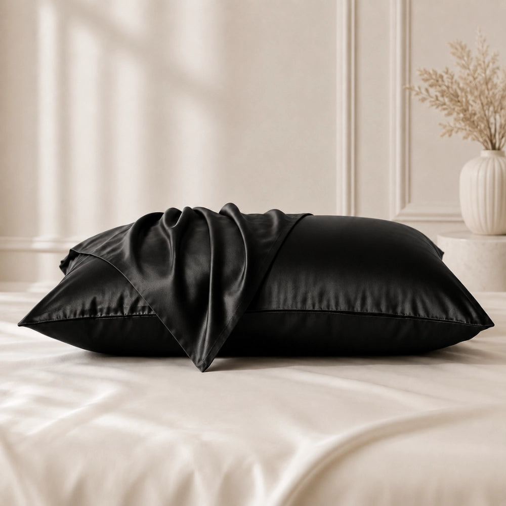 Black silk pillowcases displayed on a bed with mulberry silk pillowcases