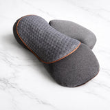 Textured cushion shown at an angle on marble surface with neck massager feel