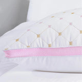 Side profile of premium hotel pillow with pink trim, soft support bedding for restful sleep