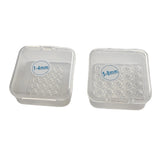 Two small refill trays containing elastic bands for skin tag removal device