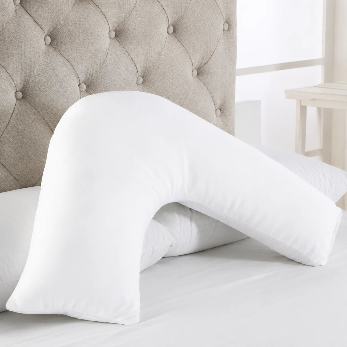 White V shaped pillow displayed on a bed for everyday support