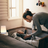 White noise sound machine placed near newborn in bassinet, creating a calm and soothing sleep space.